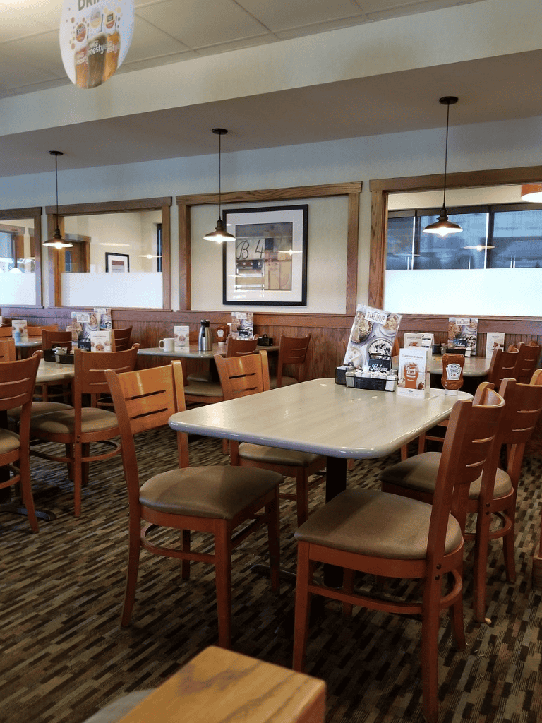 Cozy restaurant interior with wooden furniture, modern decor, and warm lighting, ideal for casual dining.