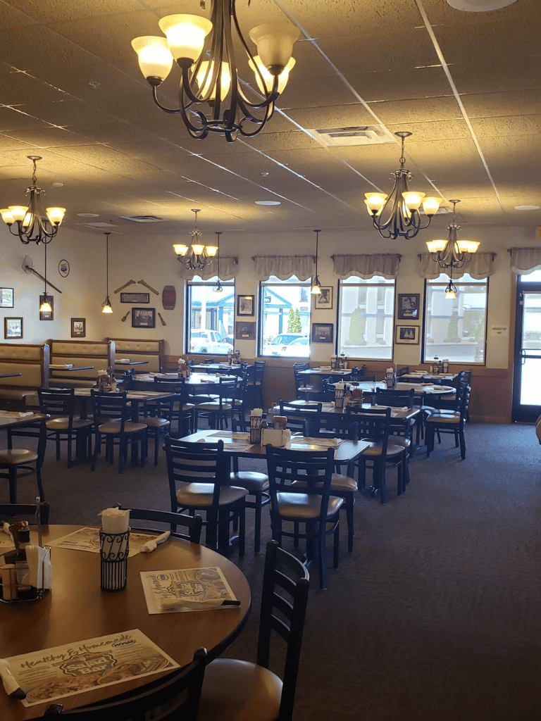 Cozy casual restaurant interior with chandeliers and framed photos, inviting atmosphere for dining at Quest For Directions.