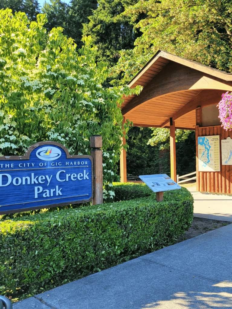 Scenic entrance to Donkey Creek Park in Gig Harbor with lush greenery and park signage.