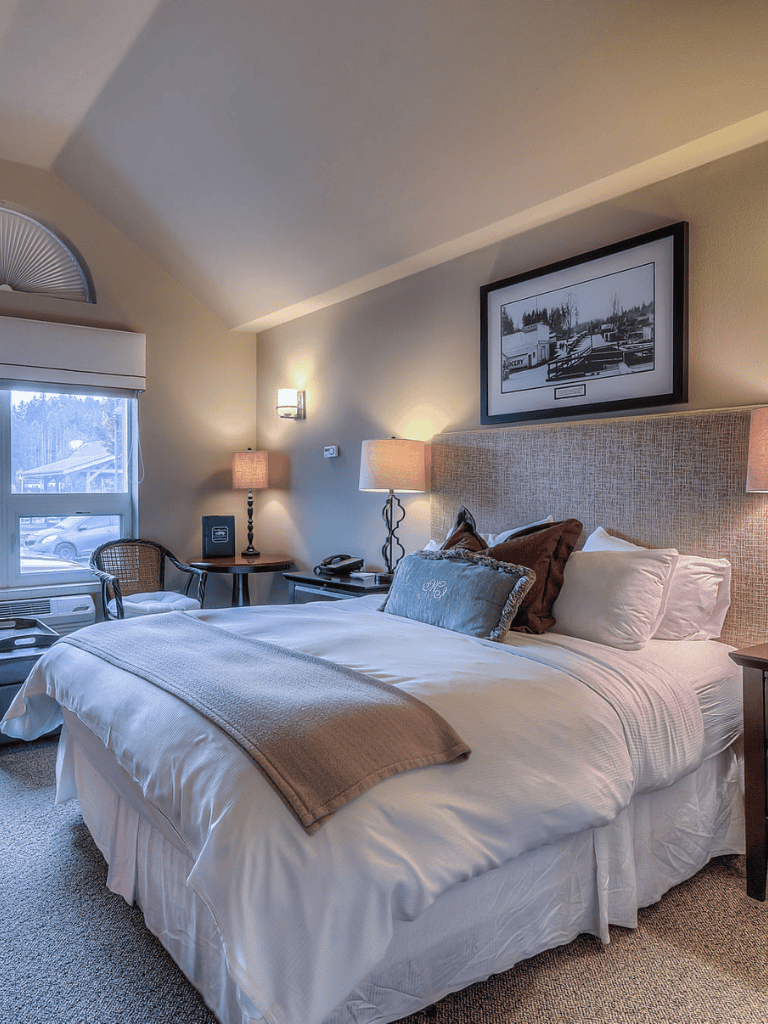 Comfortable hotel bedroom with cozy bedding and warm lighting, ideal for relaxation.