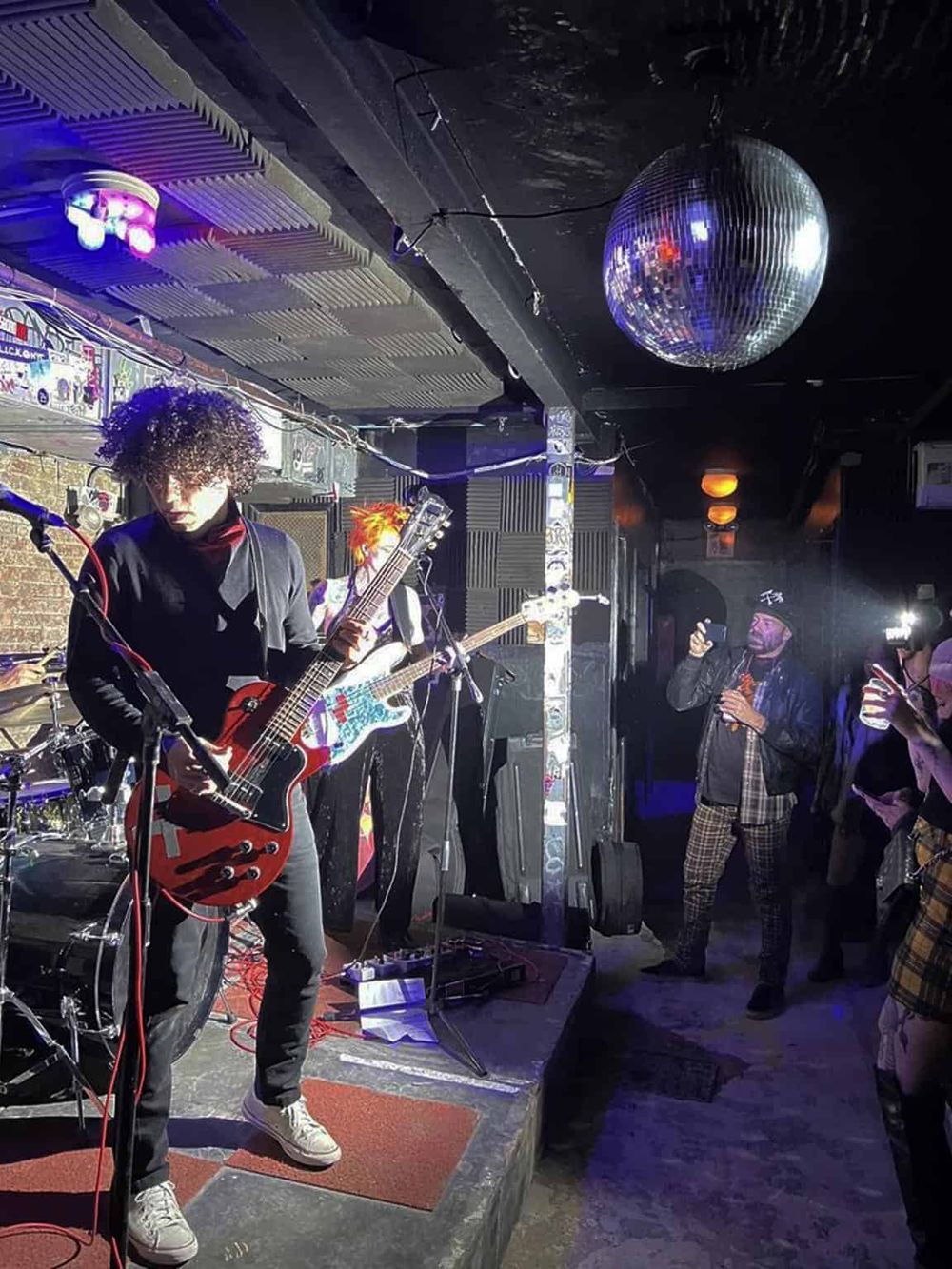 Dynamic live music performance at QuestForDirections venue with guitarist and audience engagement.