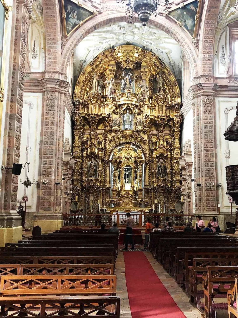 Intricate Baroque church altar with gold details, inside a historic cathedral, religious architecture, religious sightseeing, cultural heritage.
