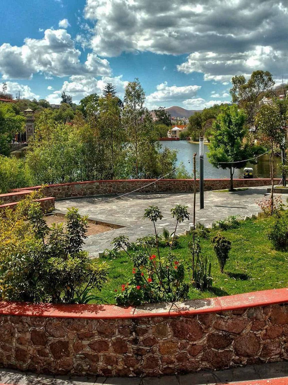 Serene lakeside park with lush greenery, scenic view, and walking paths, perfect for outdoor relaxation and nature exploration.