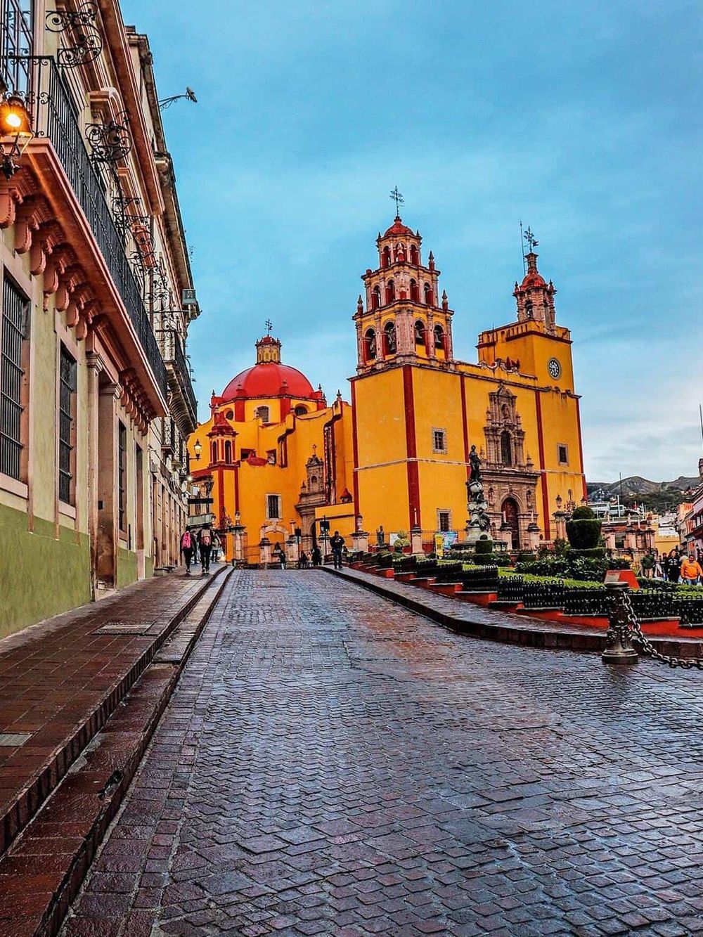 Colorful historic church in Puebla, Mexico with vibrant yellow and orange architecture.