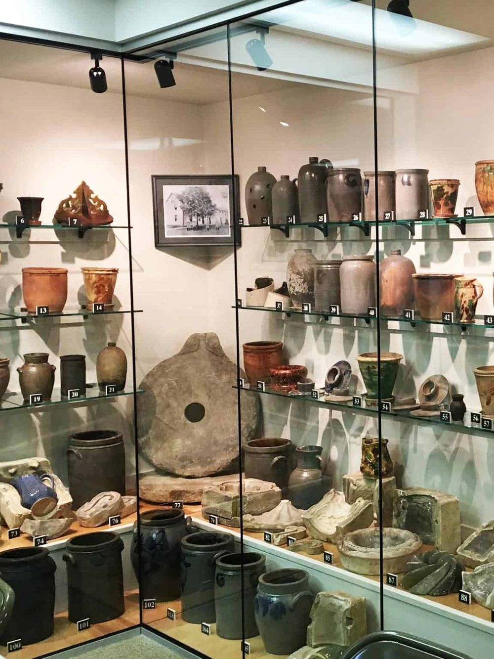 1. Antique pottery and artifacts display in museum glass case for history preservation.