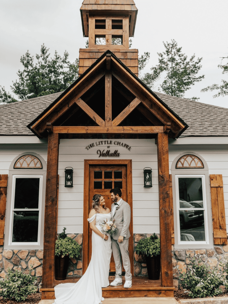 Chapel wedding ceremony at The Little Chapel in Valhalla, featuring a bride and groom in front of a rustic chapel.