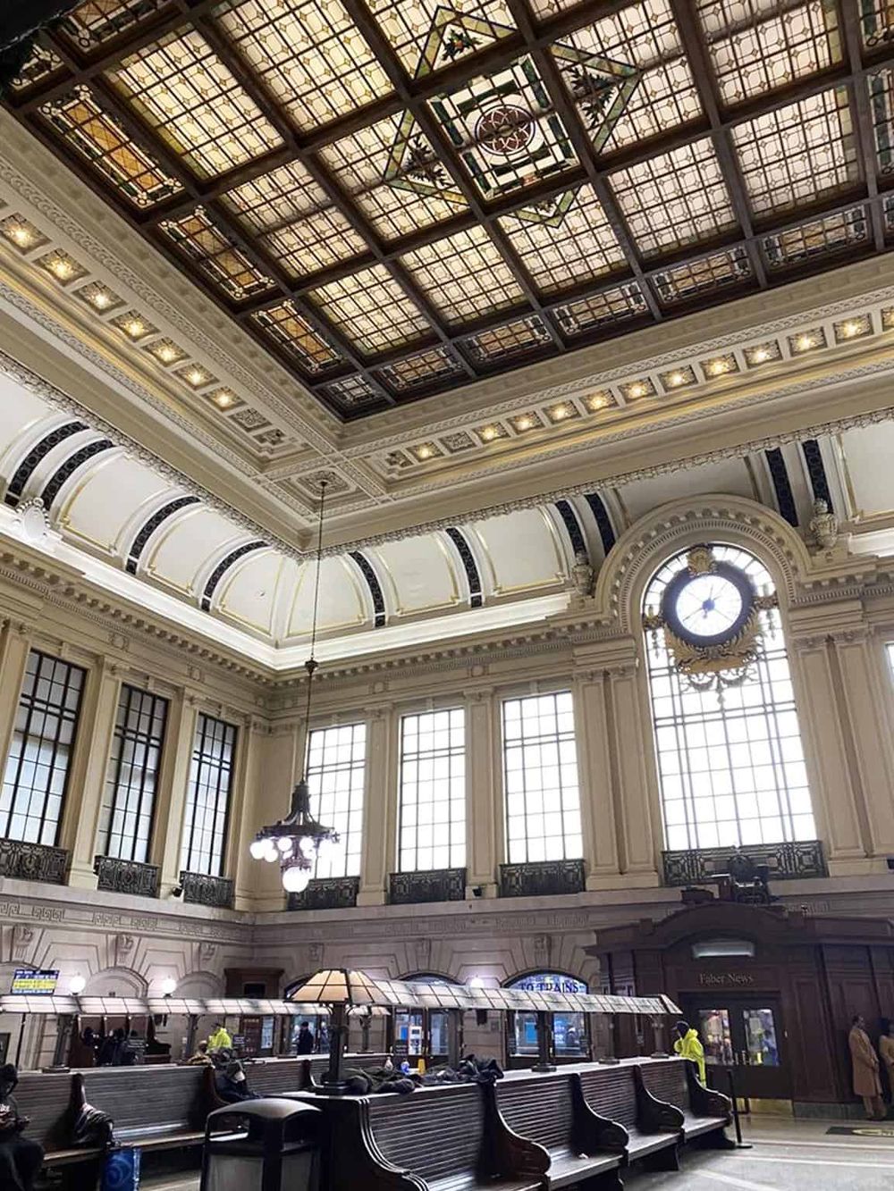 Elegant historic train station with ornate architectural details and large stained glass windows.