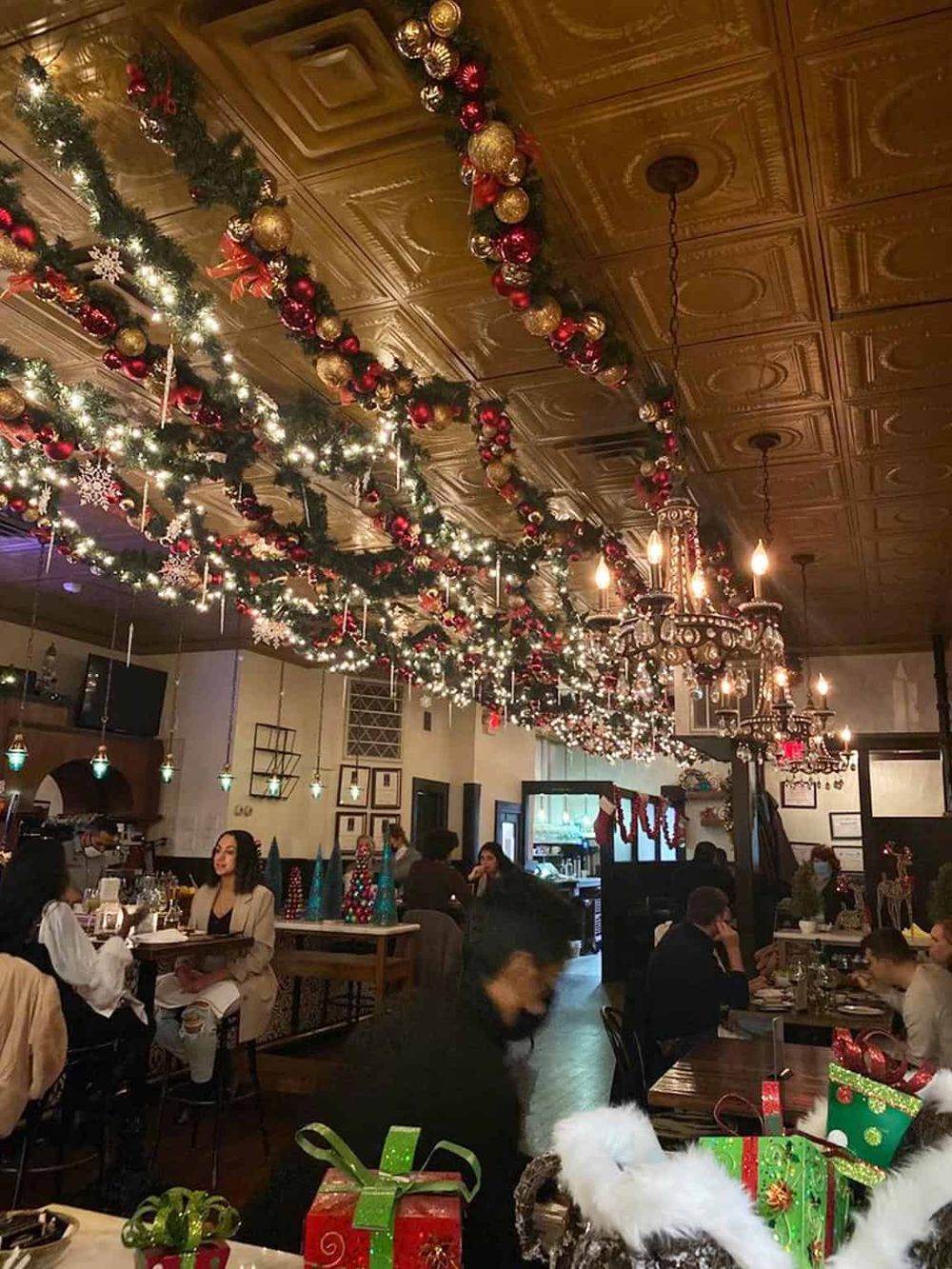 Colorful Christmas themed restaurant decorated with ornaments, lights, and holiday gifts.