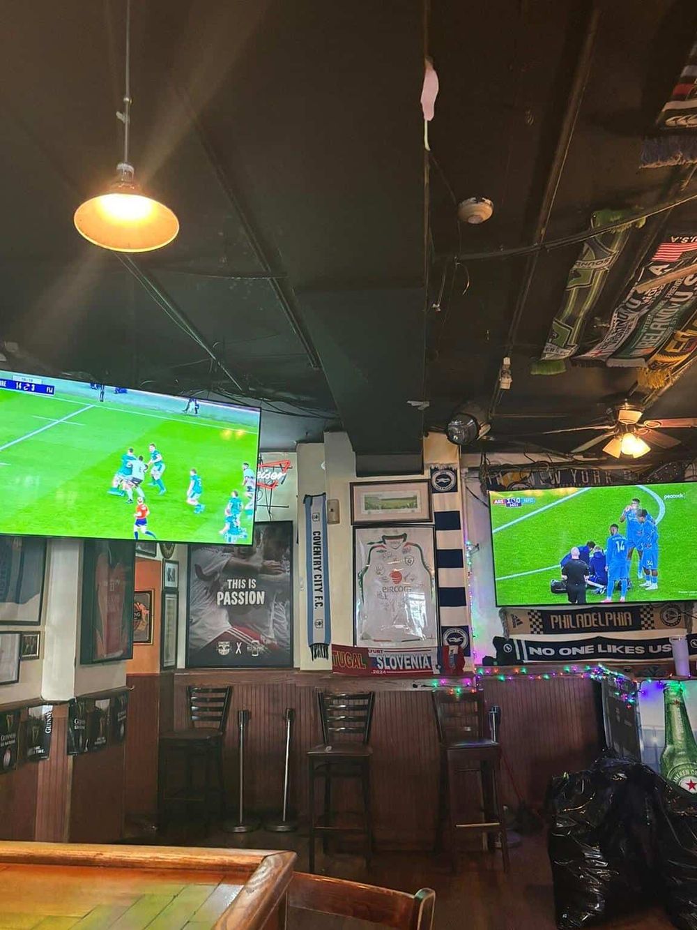 Watching soccer games at a sports bar with multiple screens, vibrant decor, and sports memorabilia. Perfect for sports fans and entertainment seekers.