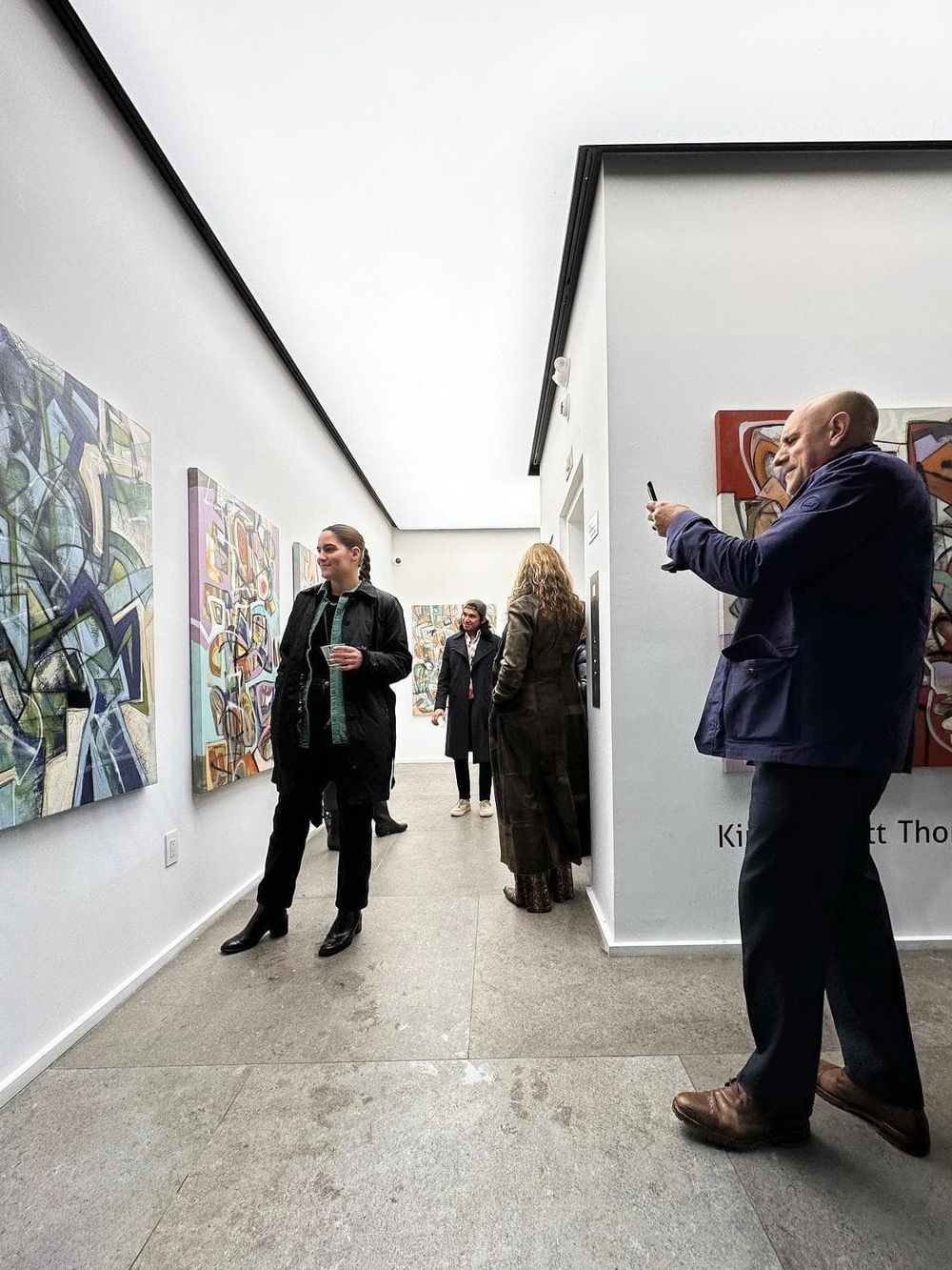 Elegant gallery visitors viewing abstract artwork at QuestForDirections art exhibit.