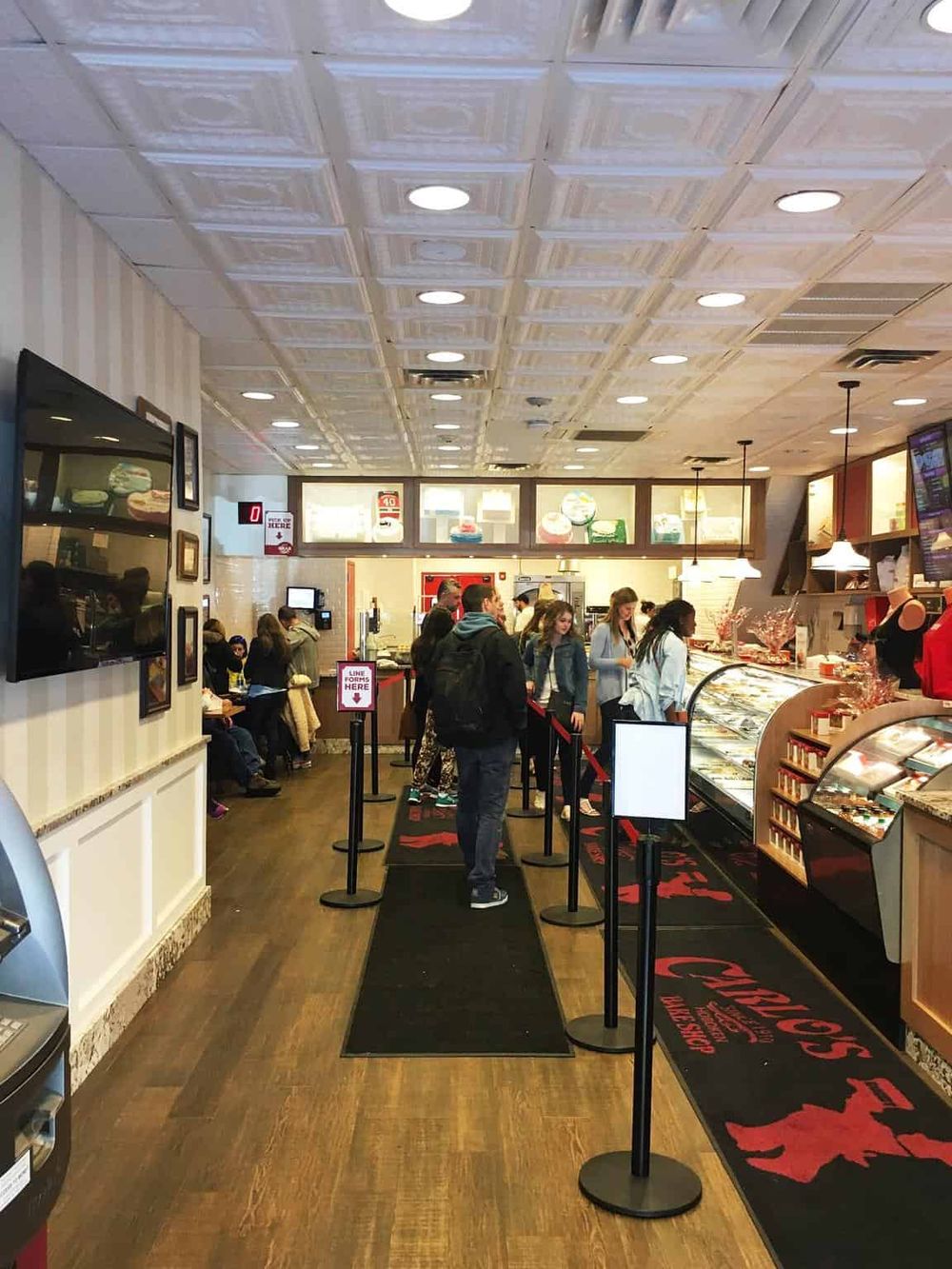 Delicious bakery and fast-food restaurant interior with customers and queue at the counter, inviting atmosphere.