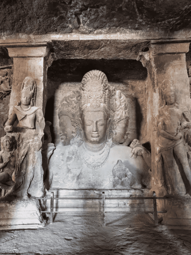 Ancient stone sculptures of Buddha and deities inside a historic cave site, showcasing religious artistry in Southeast Asia.
