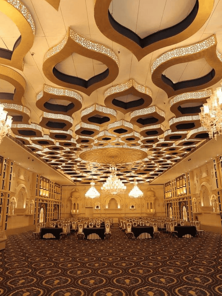 Luxurious banquet hall with ornate ceiling and elegant chandeliers, ideal for events and celebrations.