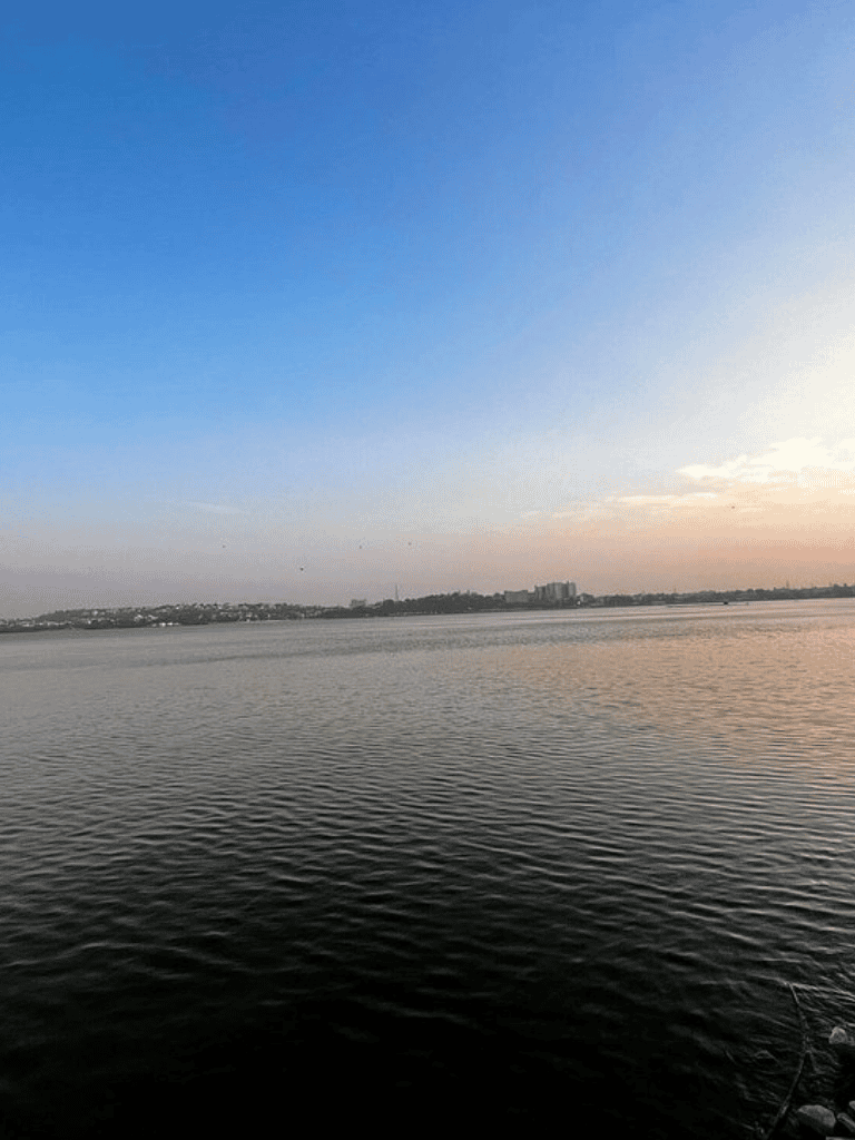 Serene water horizon at sunset with city skyline, perfect for travel and navigation themes.