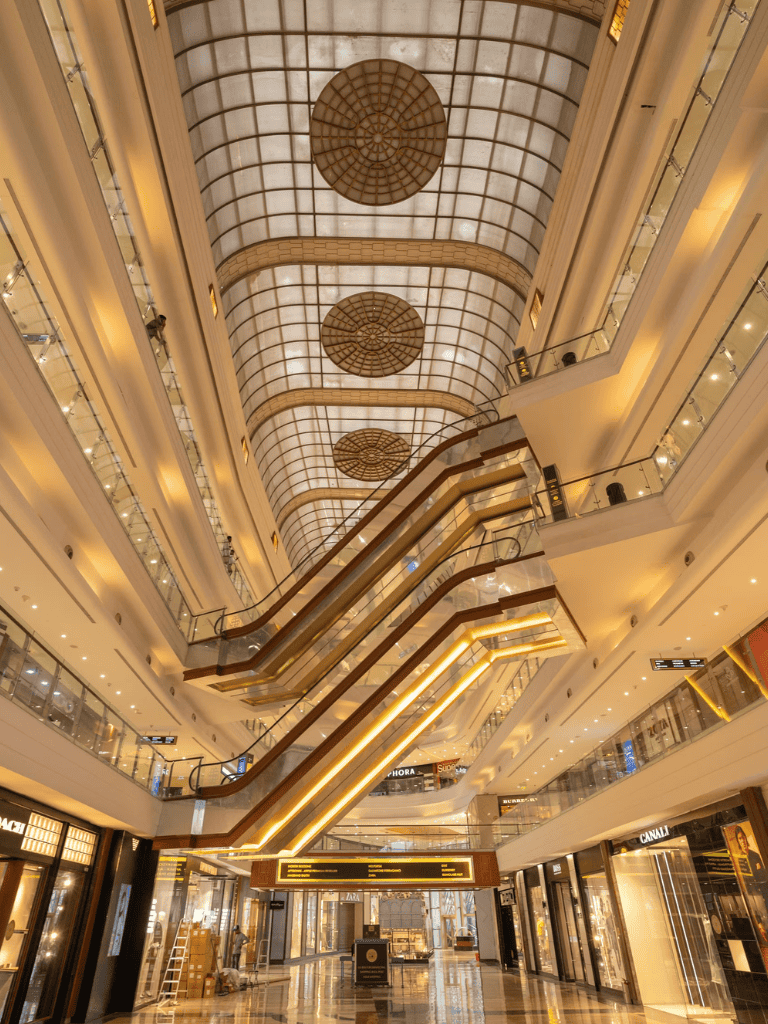 Spacious luxury mall interior with escalators and modern design elements.