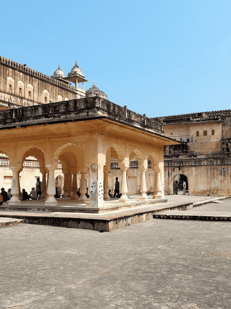 Intricate Indian temple architecture with historic stone structures and visitors exploring the site.