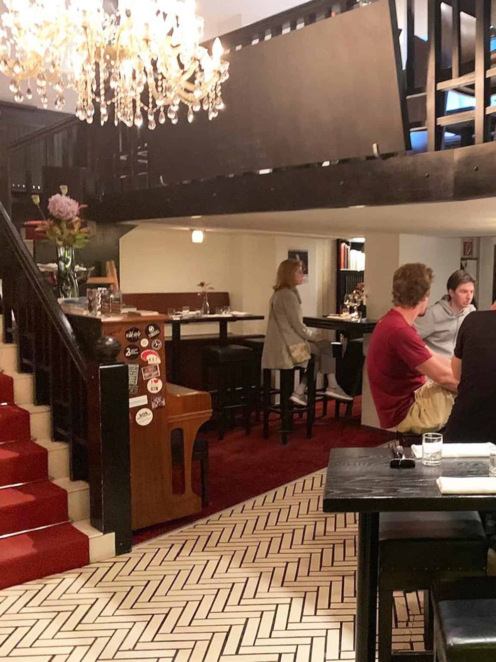 Cozy restaurant interior with elegant chandelier and guests dining, creating a welcoming atmosphere for memorable dining experiences.