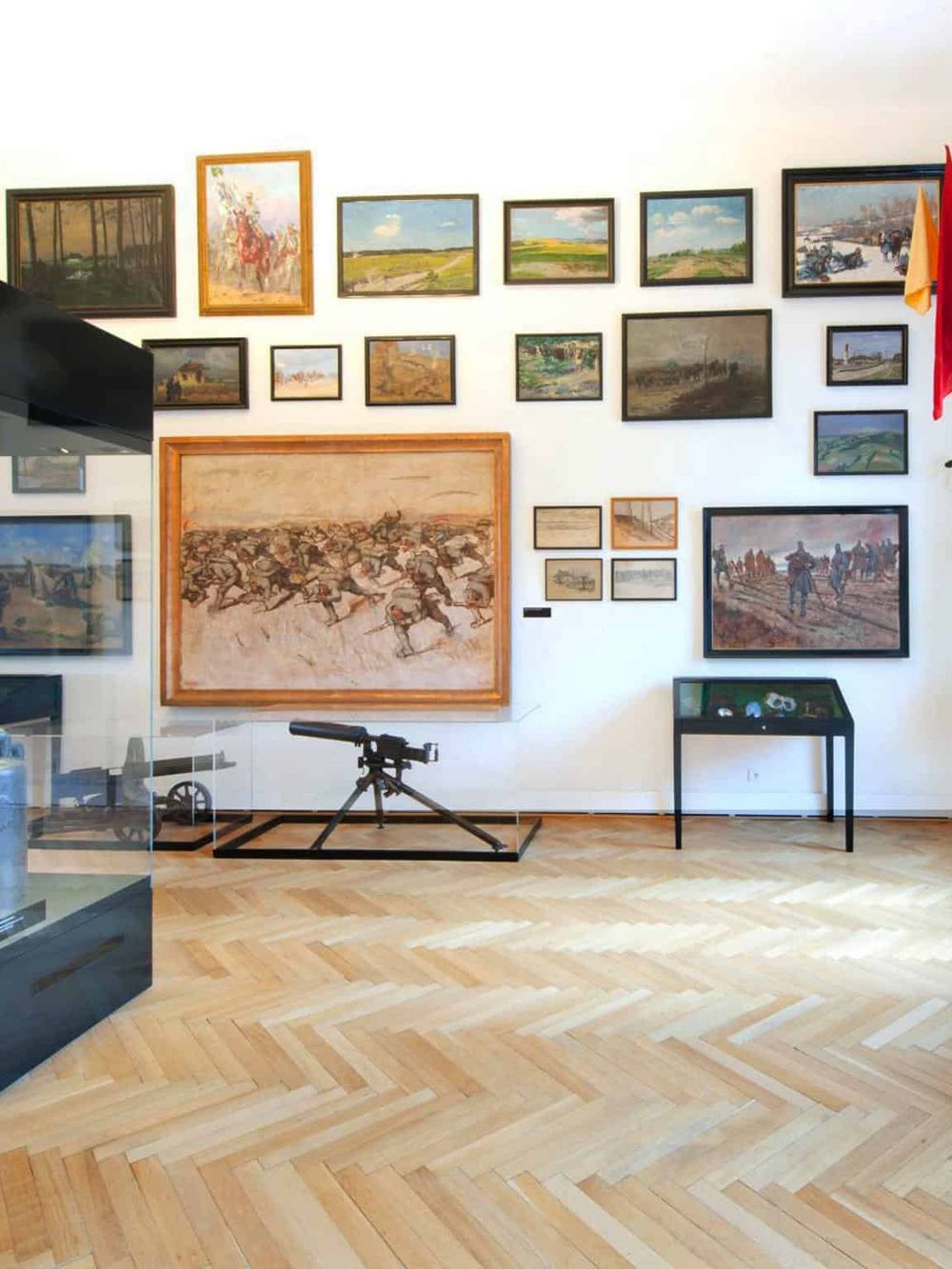 Colorful art gallery featuring paintings and a vintage rifle display at QuestForDirections museum.