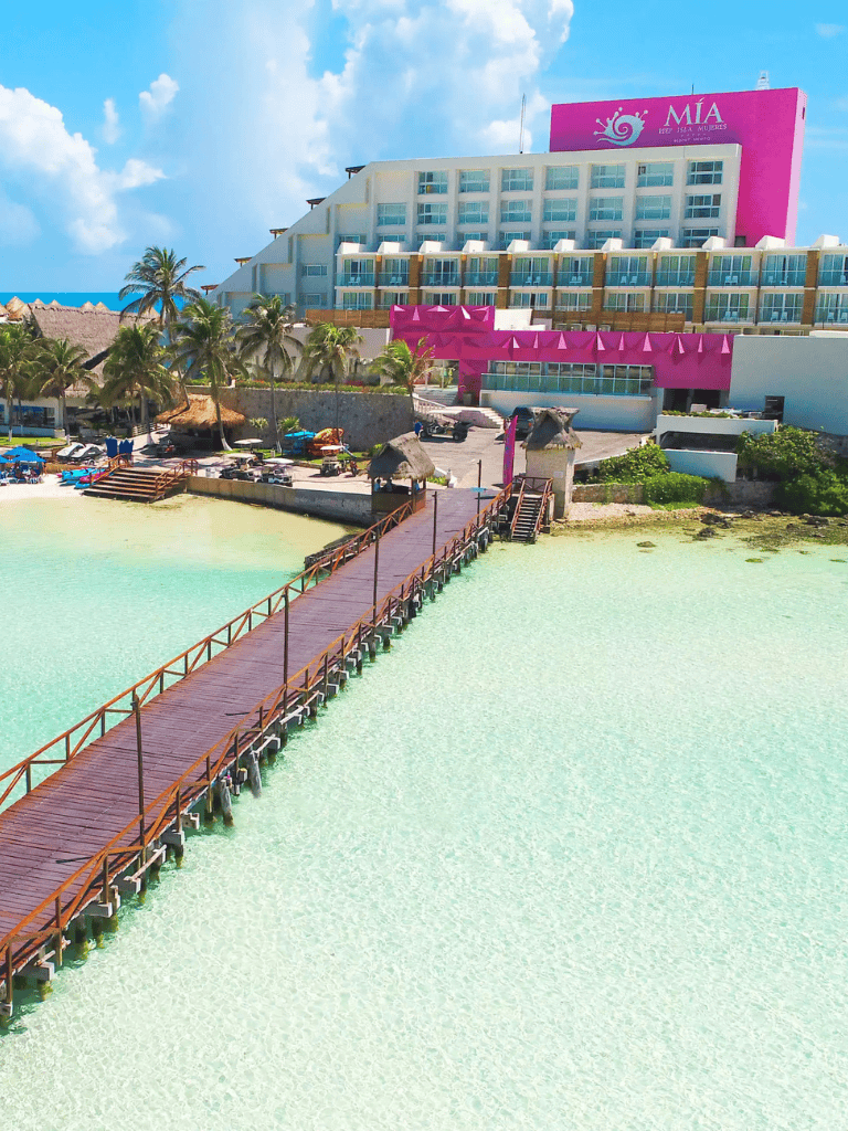 Beachfront resort with pier and ocean view, featuring luxurious accommodations and tropical surroundings.