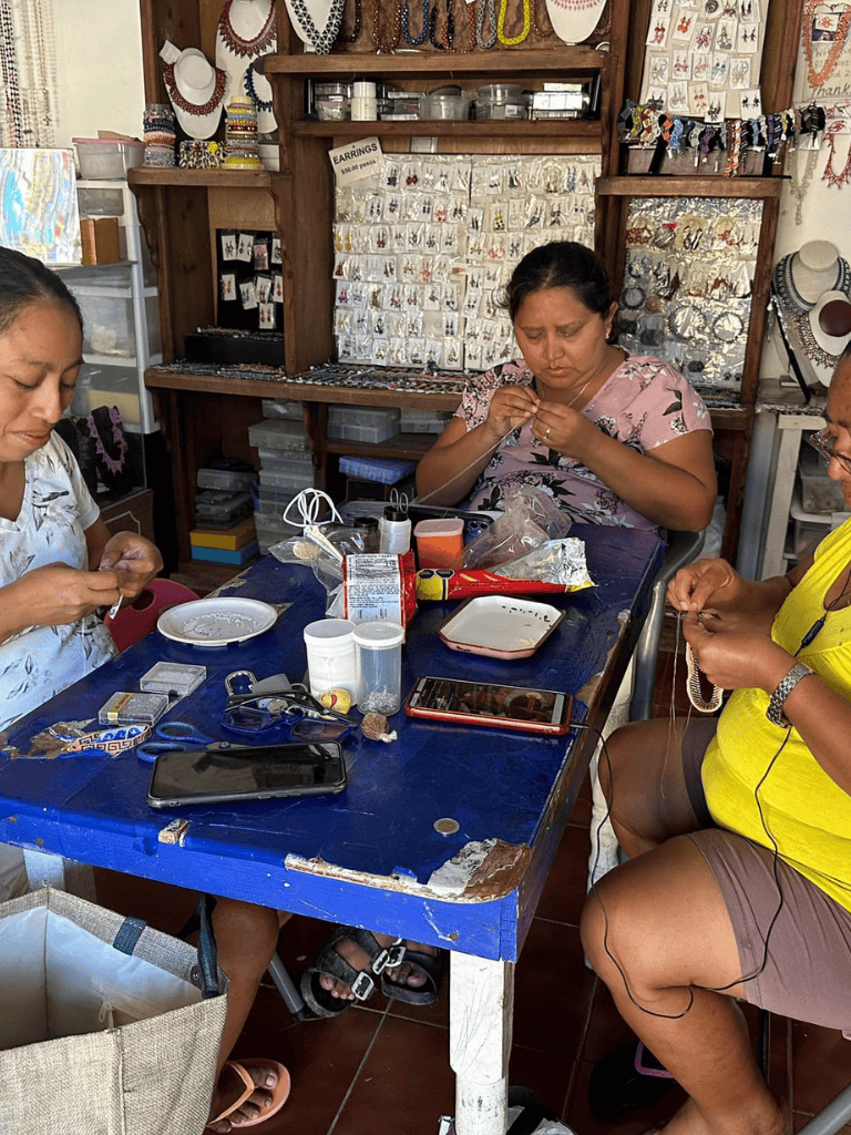 Handcrafted jewelry making workshop in Mexico, women creating jewelry in a vibrant artisan shop.