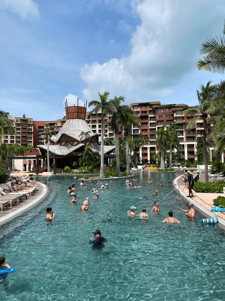 Relaxing pool scene at QuestForDirections resort with palm trees and tropical architecture.