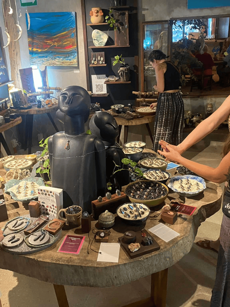 Colorful art gallery showcasing indigenous jewelry and artifacts with visitors exploring exhibits.