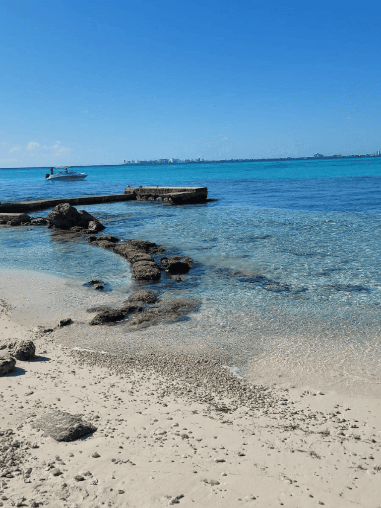 Serene beach with clear blue water and rocky shoreline, perfect for seaside relaxation and scenic ocean views.