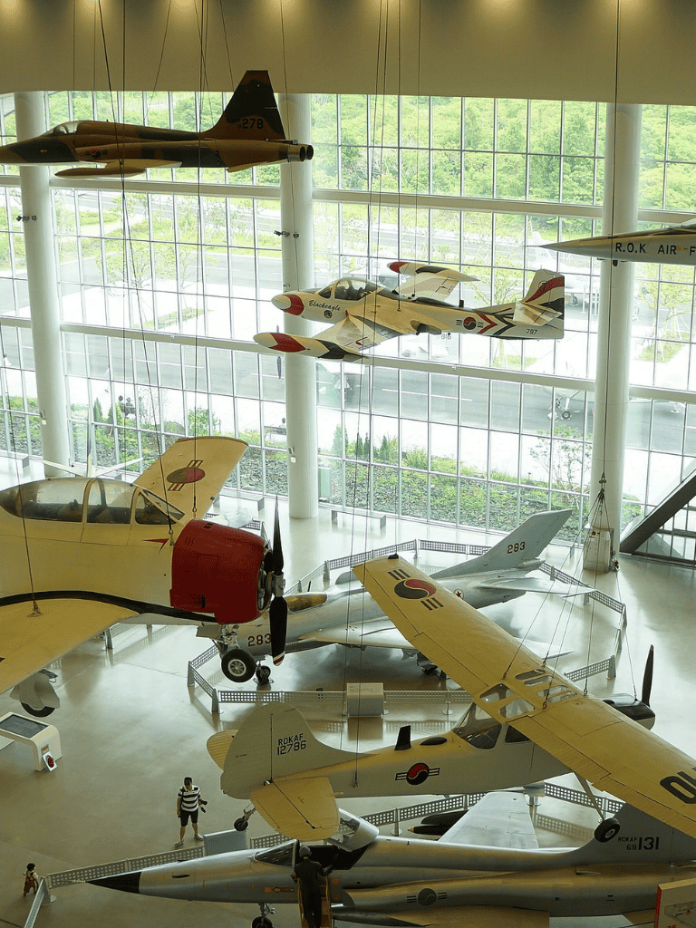 Military aircraft display at aviation museum with vintage jets and fighter planes.