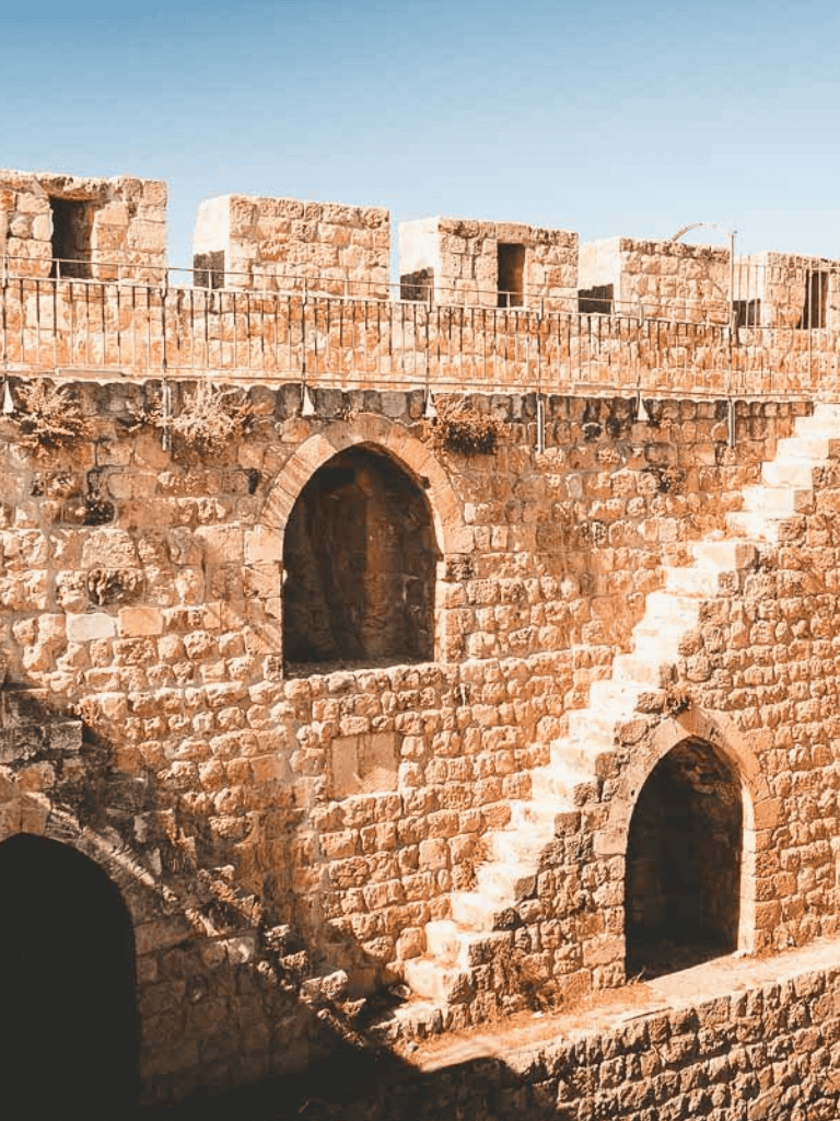 Ancient stone fortress with stairs and arched doorways, historical site for travel and exploration.