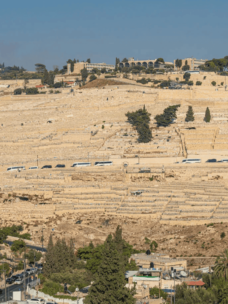 Ancient amphitheater with modern buildings on a hillside in Jerusalem, Israel.