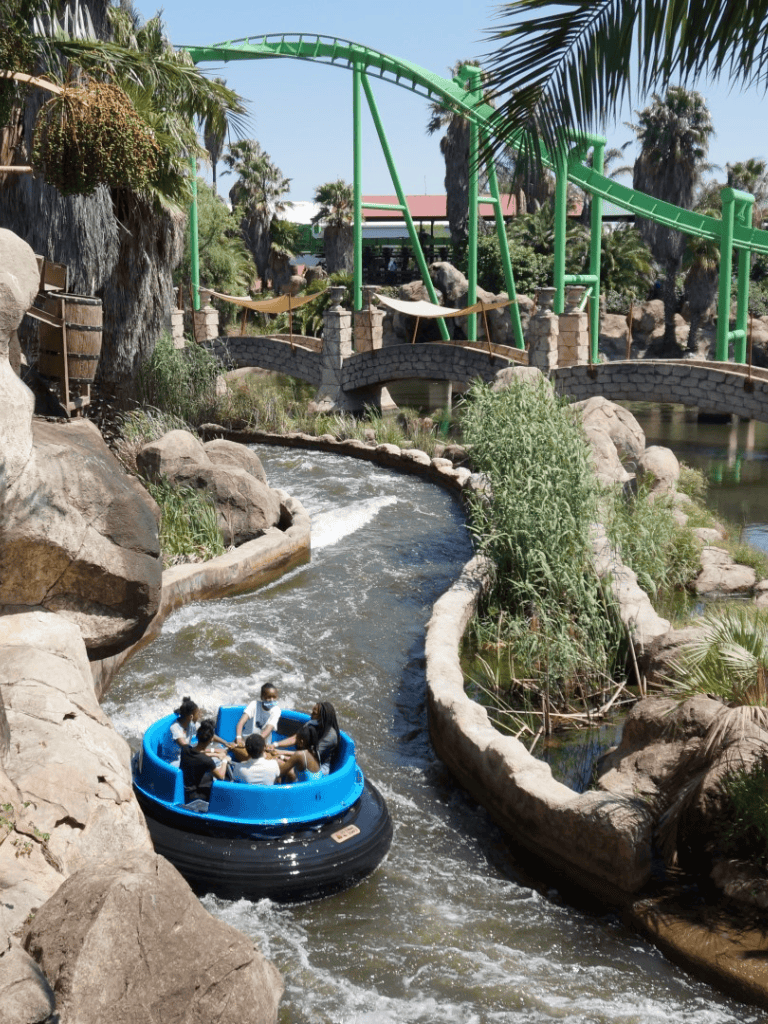 Thrilling river rapids ride at Quest for Directions theme park with lush tropical scenery.