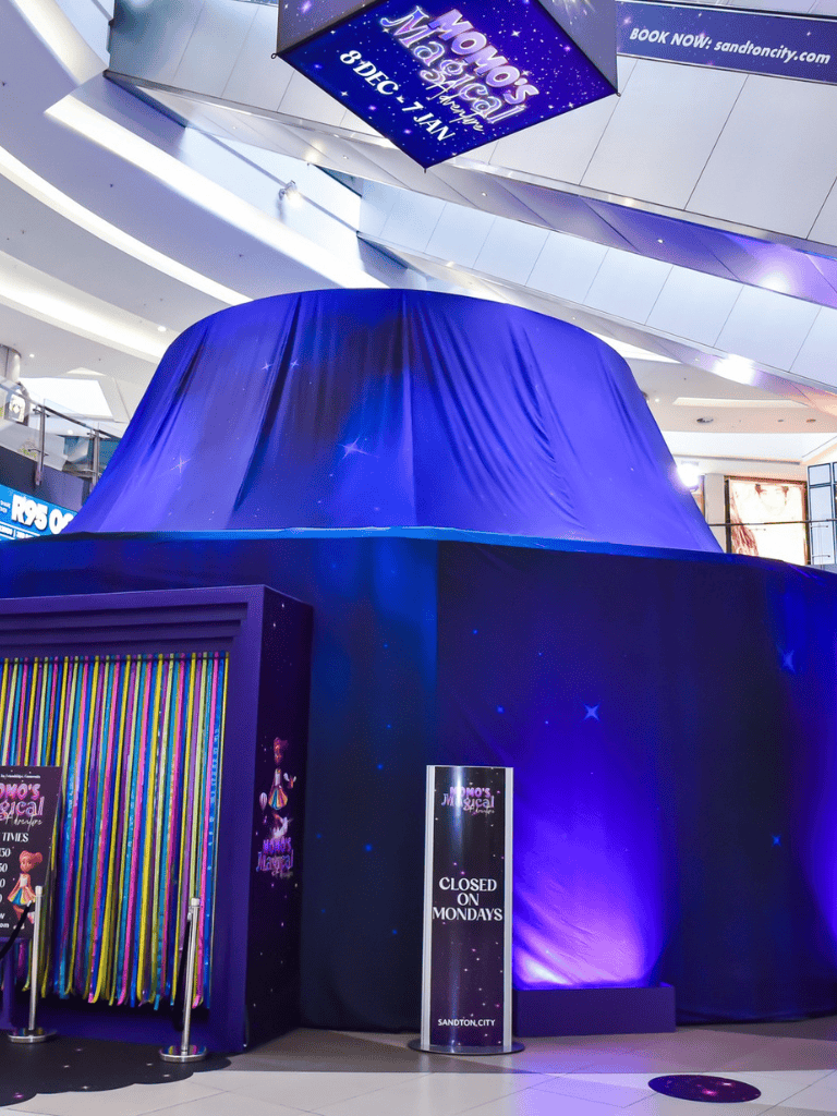 1. Large blue fabric-covered display at Quest for Directions shopping mall.