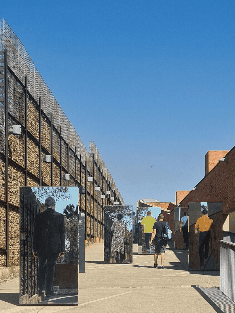 Mirrored art installation at QuestForDirections urban sculpture park, outdoor public art exhibit, innovative cityscape artwork.