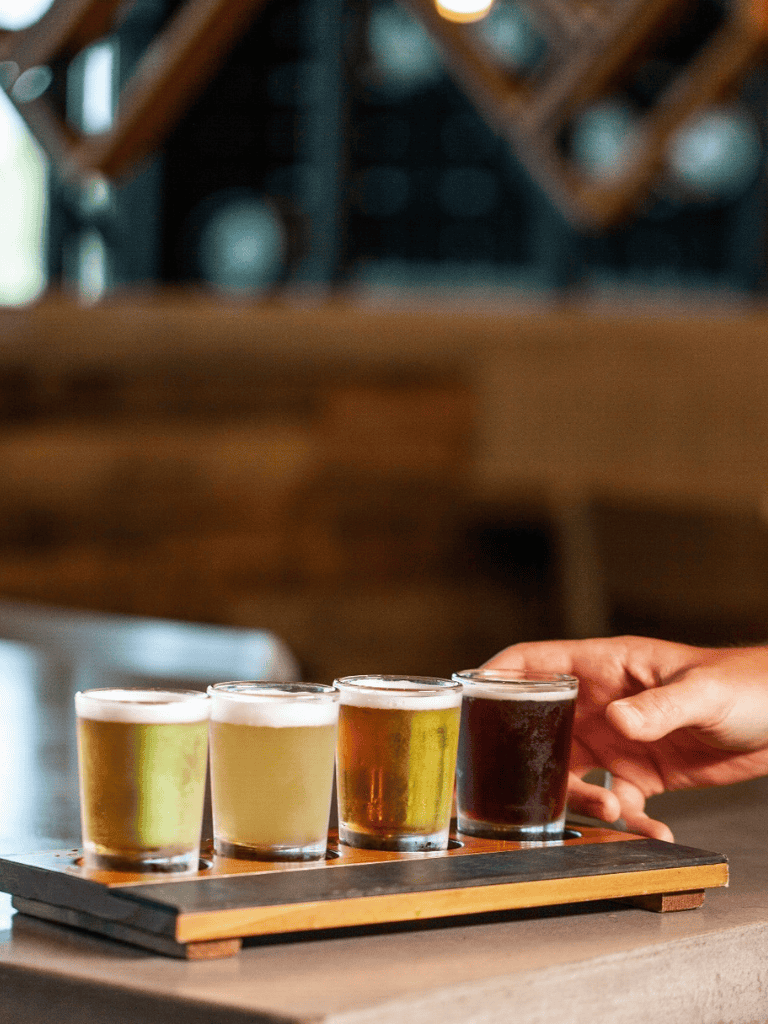 Craft beer tasting flight at a cozy brewery, showcasing variety and flavor.
