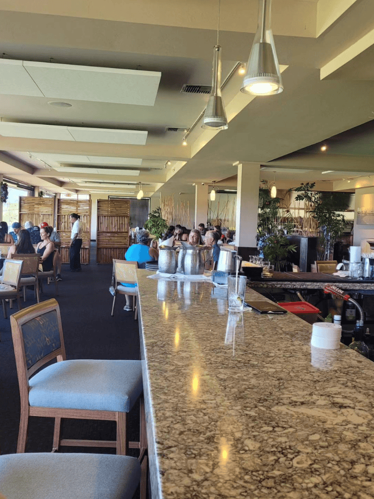 Bright modern restaurant interior with bar seating, lively atmosphere, and stylish decor - perfect for dining and socializing.