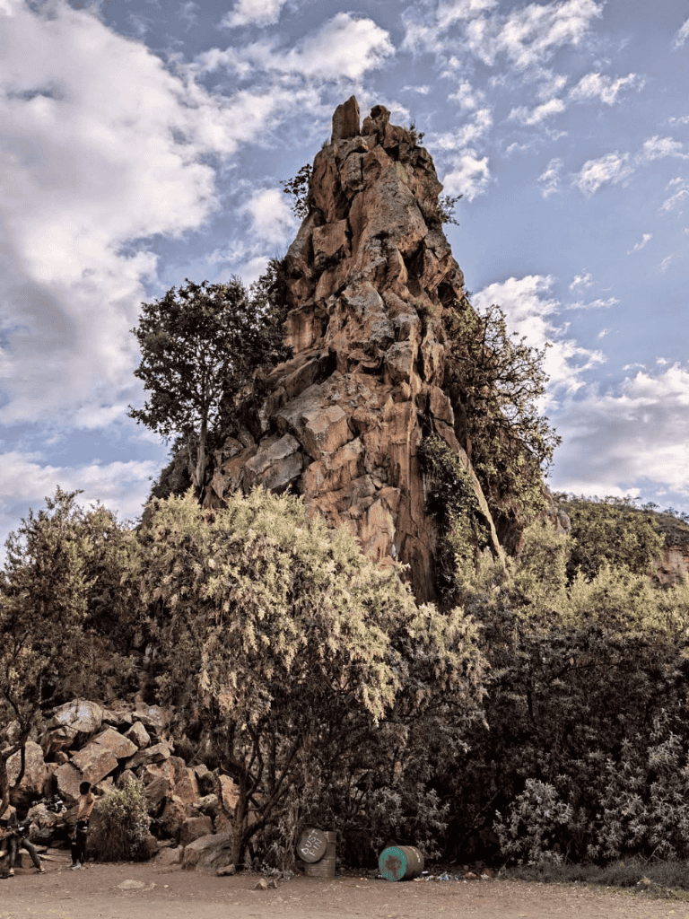 Ancient rocky formation in Bardenas Reales, Spain, surrounded by desert vegetation and blue sky.