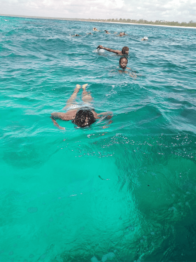 People swimming in the ocean during daytime.