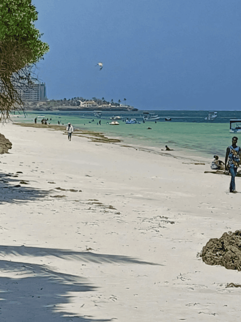 Relaxing beach scene with boats and kite surfing for travel and leisure SEO.