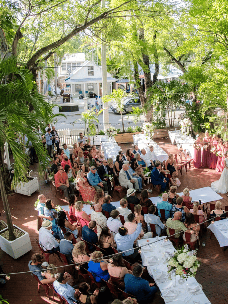 Wedding ceremony at QuestForDirections outdoor venue with guests, greenery, and elegant decor.