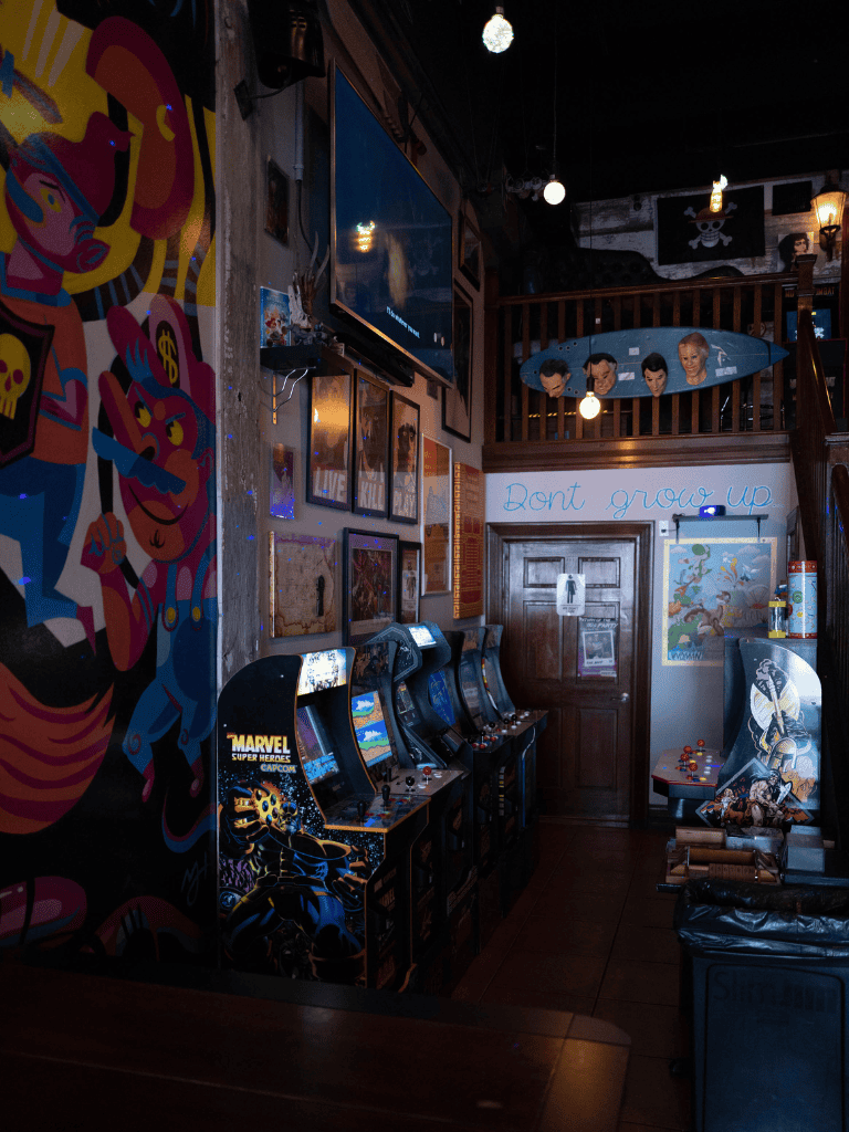 Arcade gaming room with vintage arcade machines and vibrant wall art at QuestForDirections.