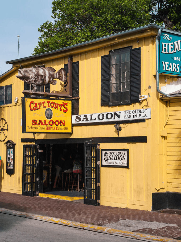 Colorful Florida bar with vintage signs and a fish sculpture.
