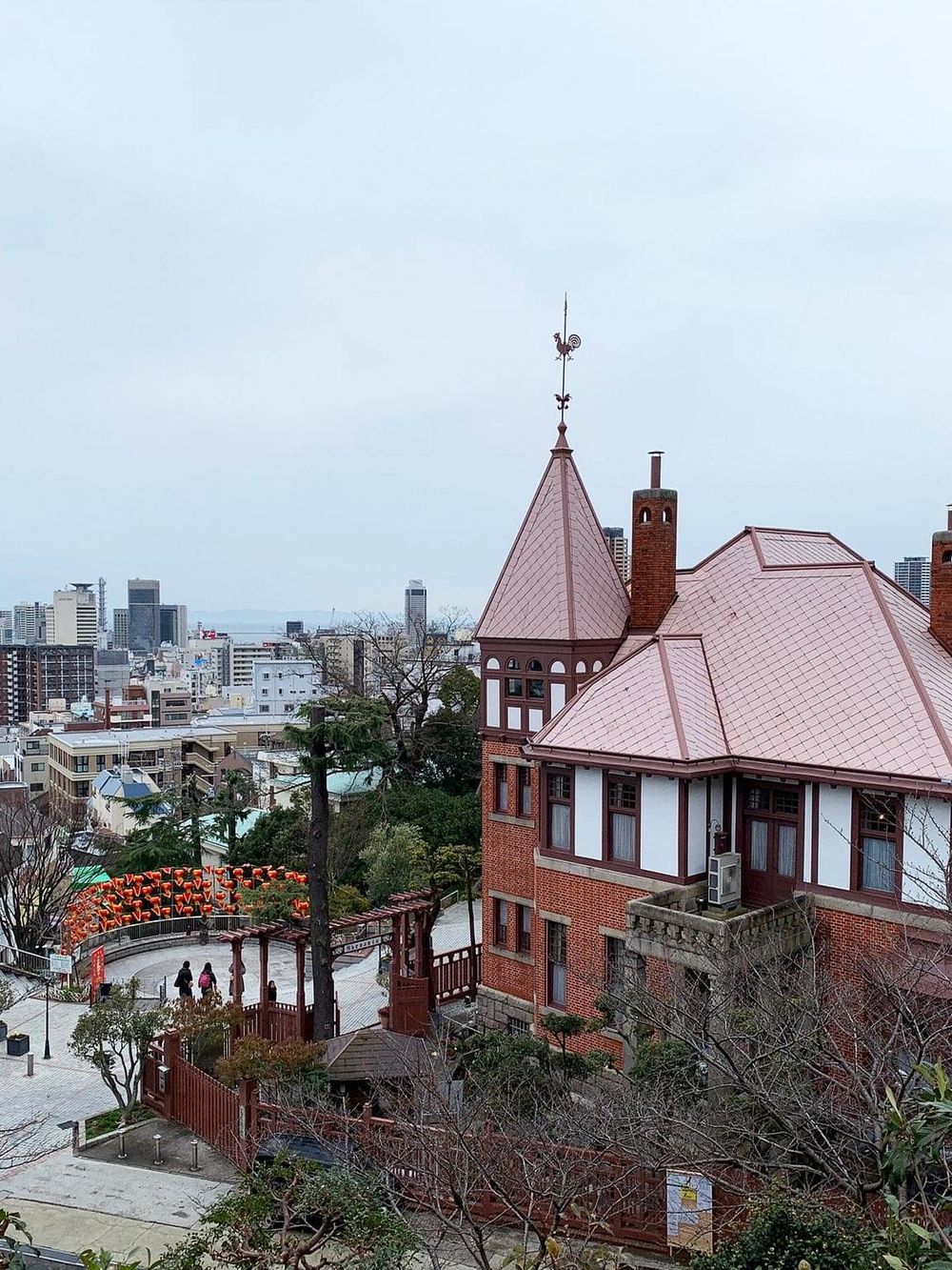 Victorian-style brick house with a rooftop turret and city skyline in the background, showcasing San Francisco architecture.