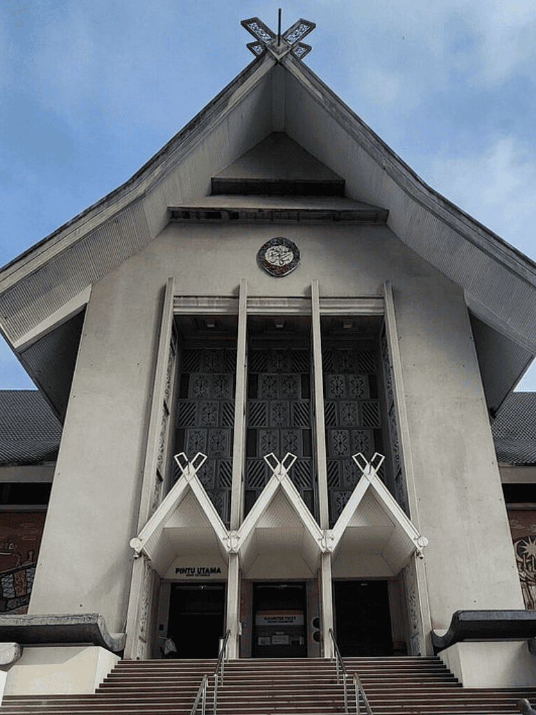 Modern church building with unique architectural design and clock, located in Indonesia.