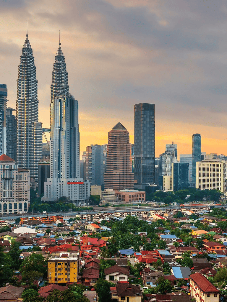 Modern Kuala Lumpur skyline with Petronas Towers and vibrant cityscape at sunset.
