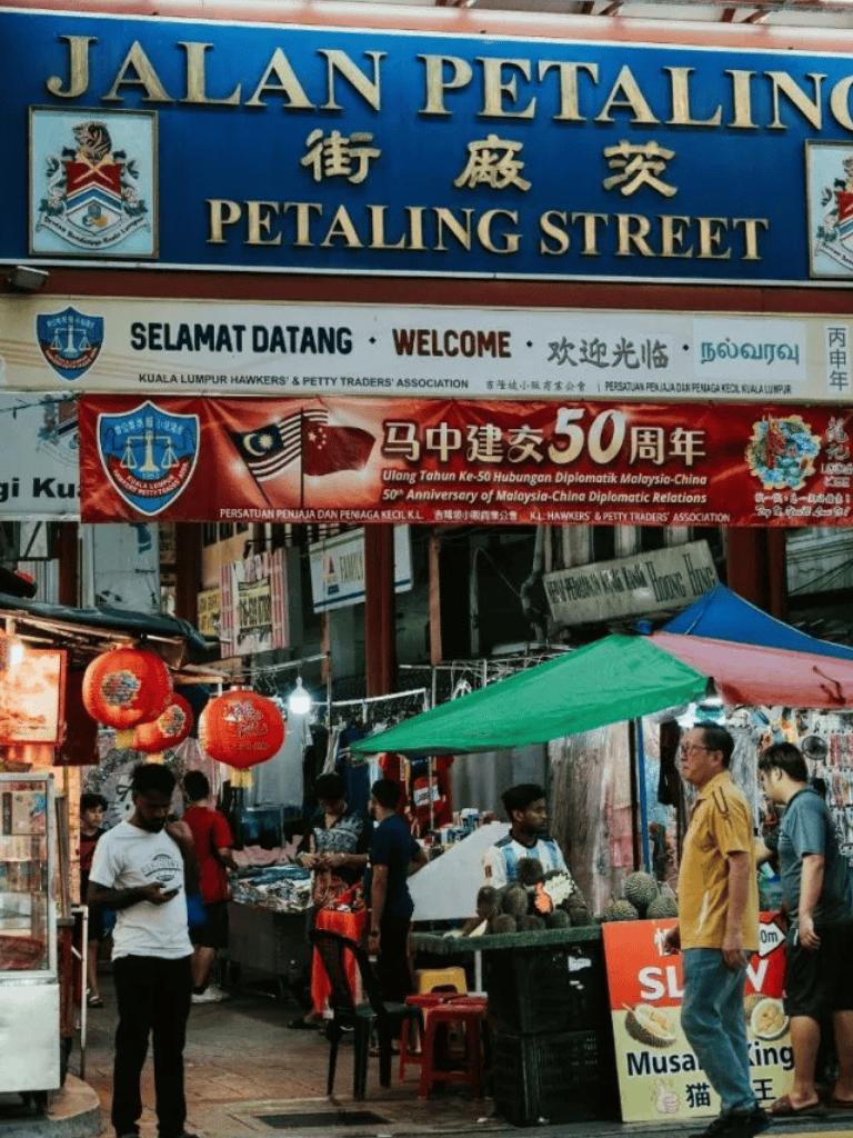 Jalan Petaling street bustling market scene in Kuala Lumpur with shoppers and street vendors.