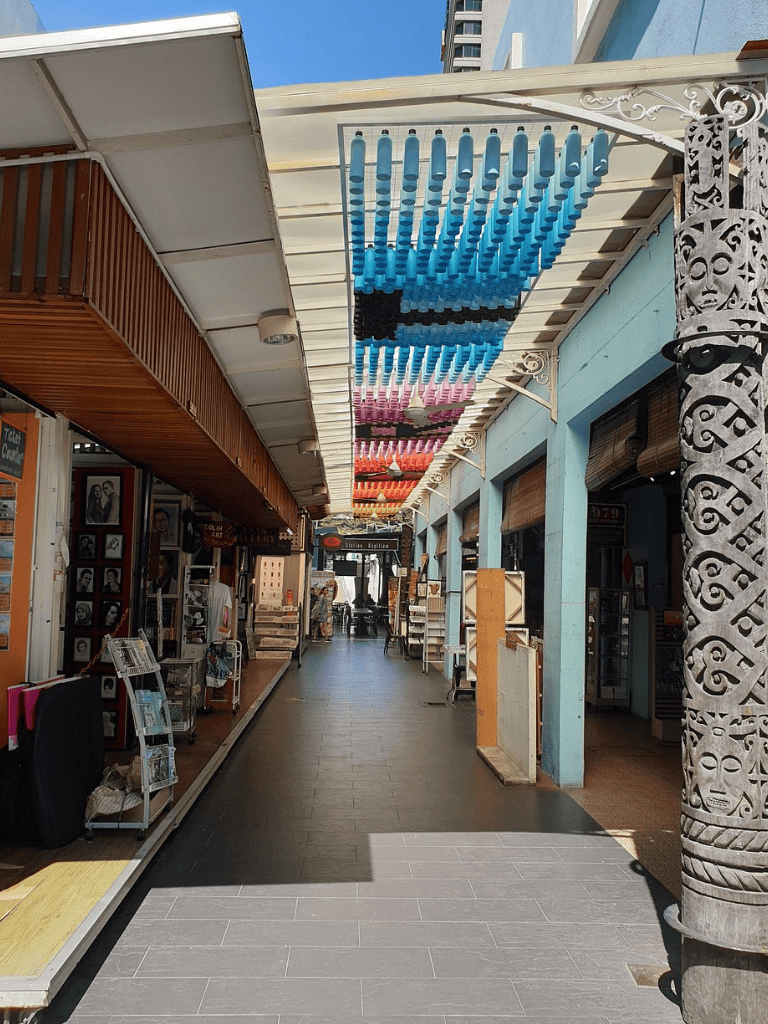 Colorful hanging bottle display in a marketplace corridor, vibrant shopping and tourist destination.