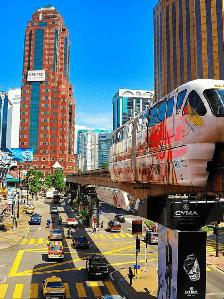 Bright cityscape with monorail train and high-rise buildings in downtown Kuala Lumpur, Malaysia.