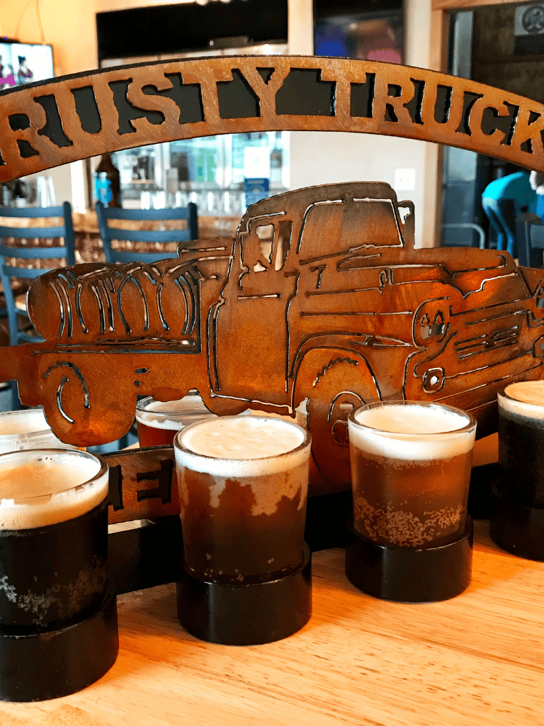Rusty truck metal sign at a cozy bar with craft beers, inviting atmosphere, and rustic decor.