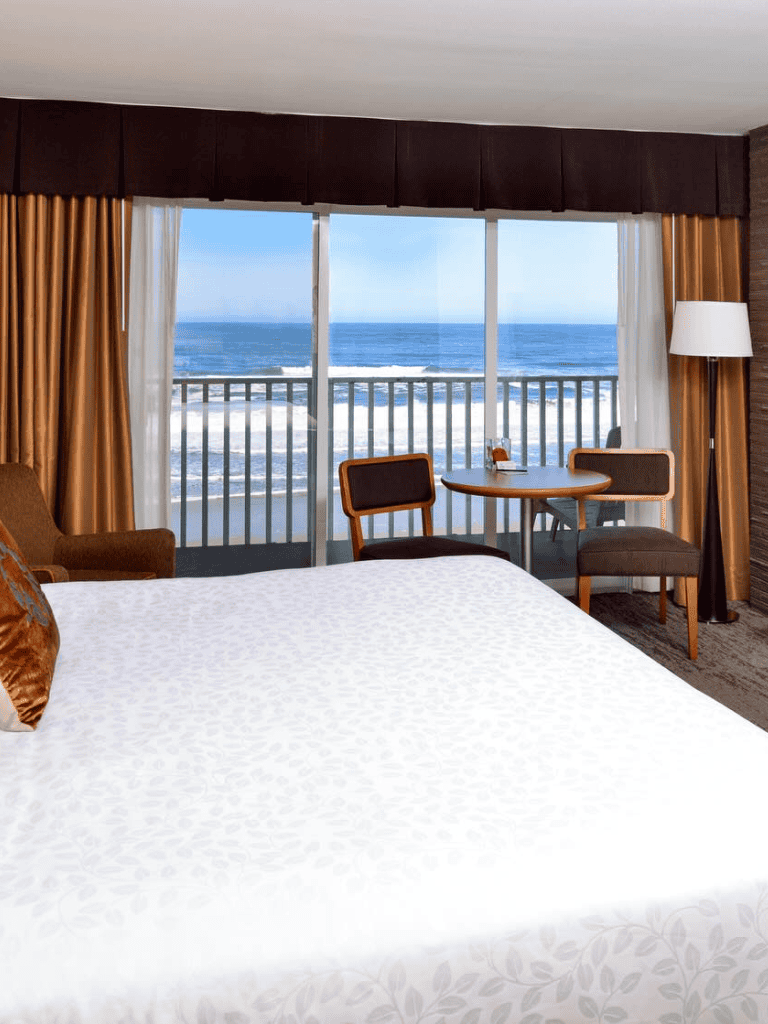 Breathtaking ocean view from hotel room with balcony and elegant interior decor.
