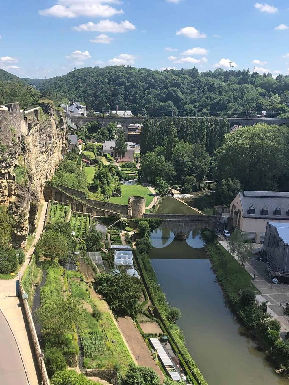 Scenic view of historic houses, lush greenery, and the river at Quest for Directions. Explore top travel destinations and travel tips.